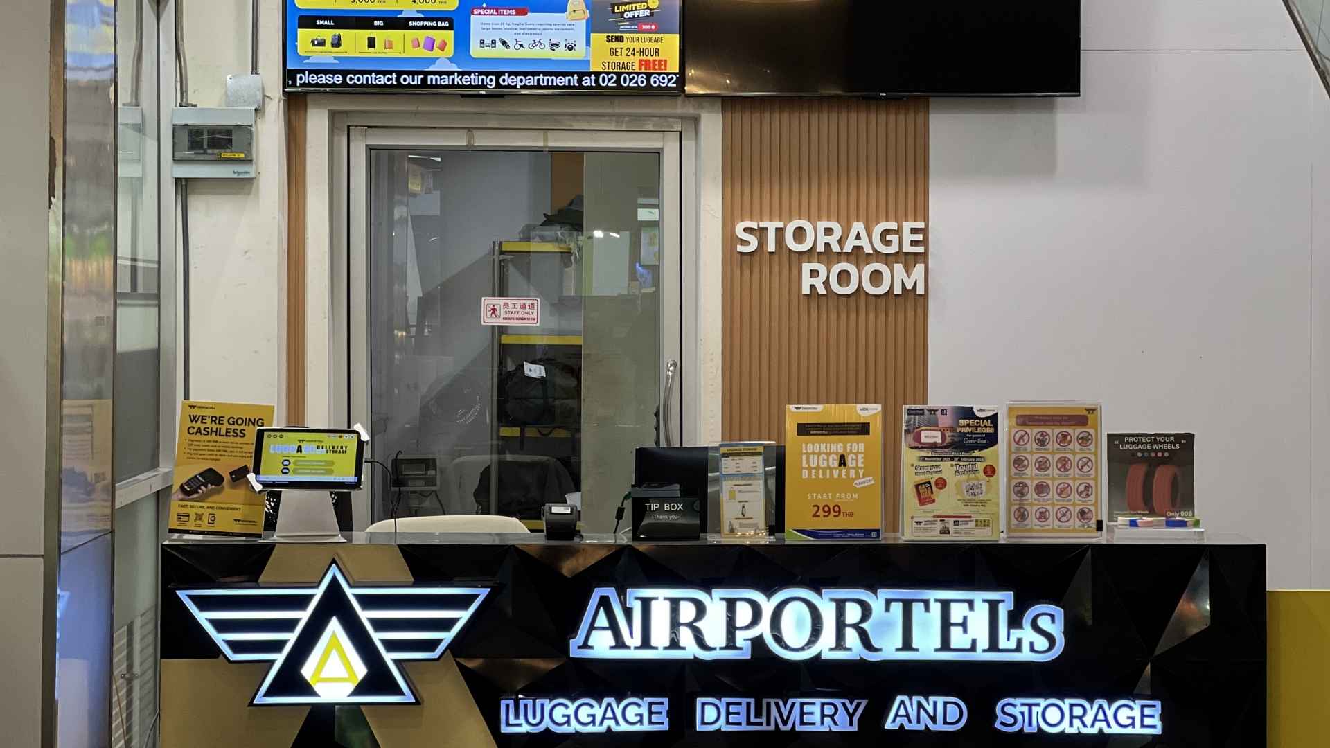 The AIRPORTELs counter at MBK Center: staffed desk, published price board and the secure storage room behind it