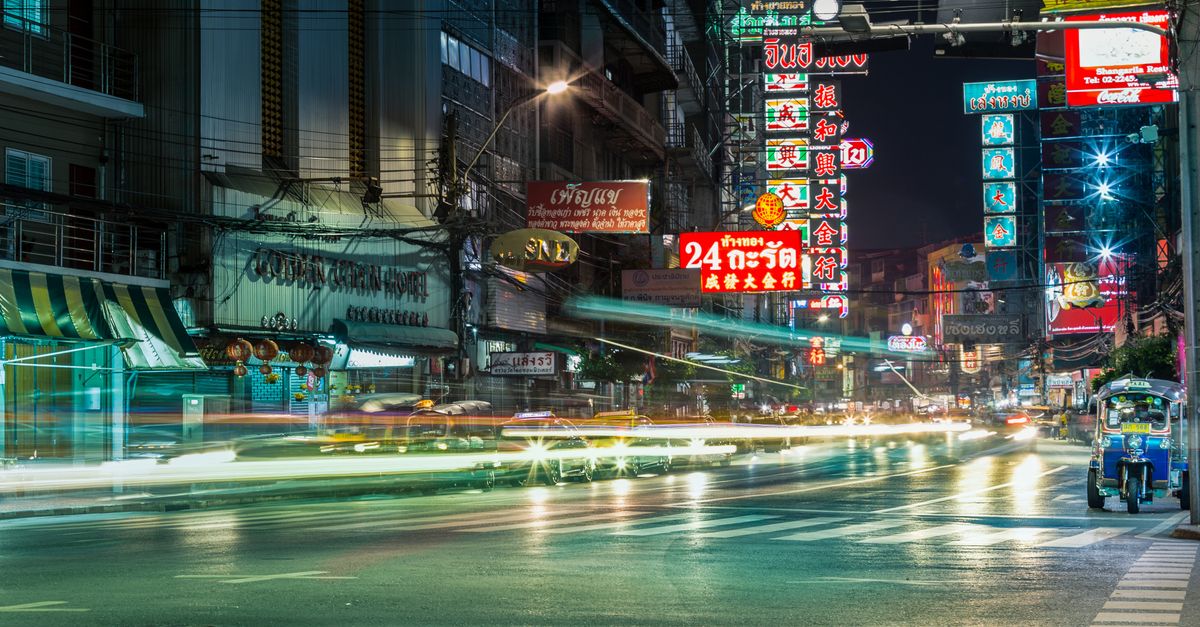 Evening traffic and neon lights on a busy Bangkok street