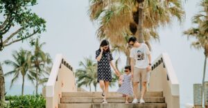 Alt: Parents leaving a Bangkok hotel hands-free with only a stroller and a daypack after sending their luggage ahead