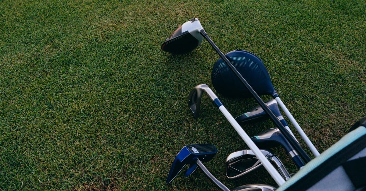 Golf clubs padded with towels and a support rod inside a travel cover before shipping