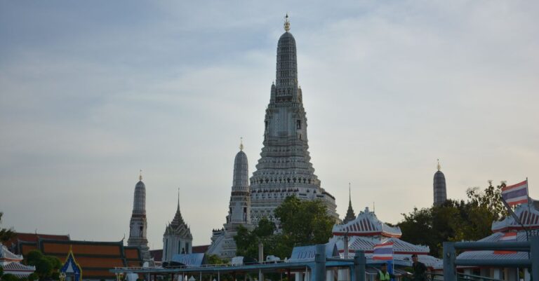 Alt: Transit passenger with only a daypack watching sunset over Wat Arun during a one-day Bangkok stopover