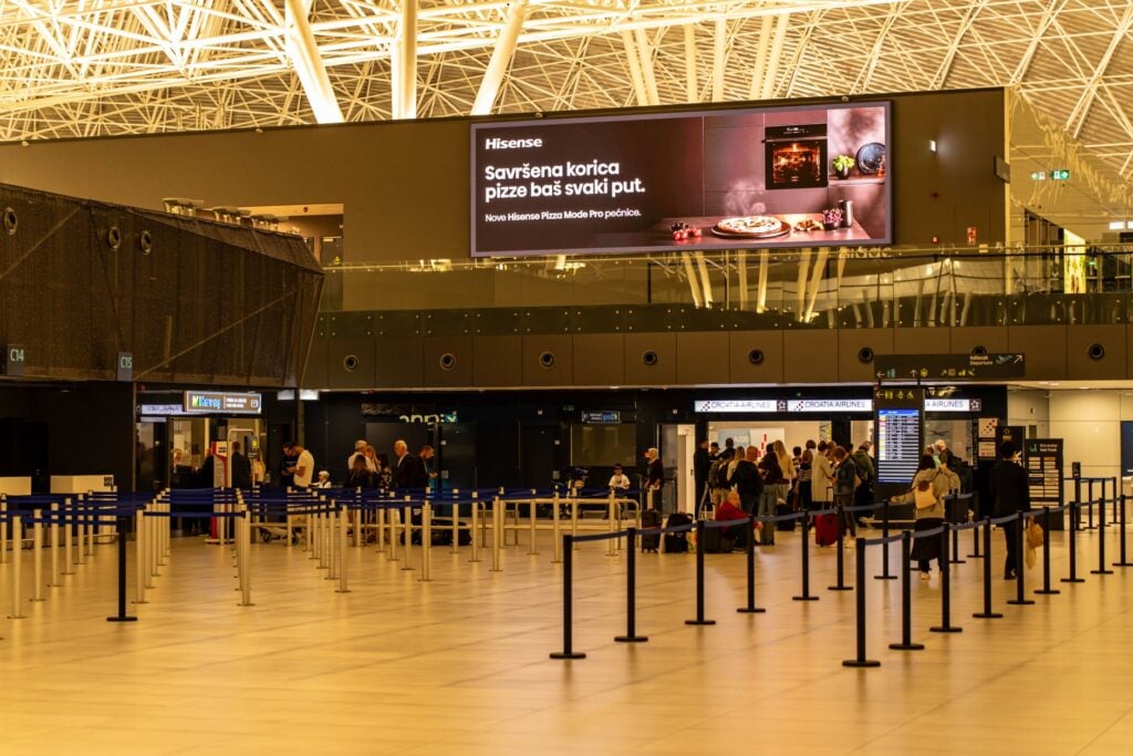 Airport check-in hall lit from above, with the desks empty