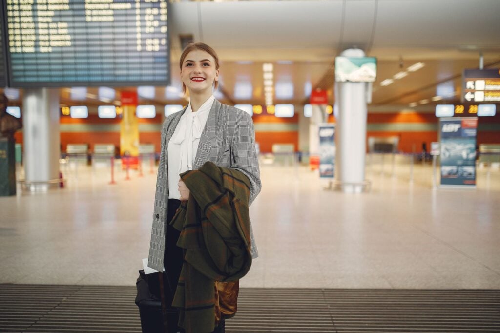 Traveller with a coat over one arm in a departure terminal